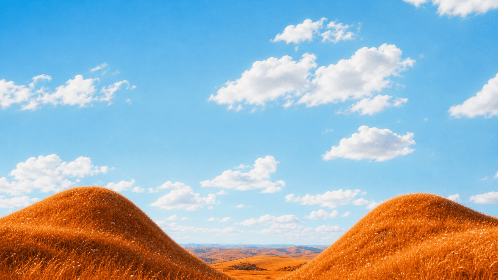 Orange rolling hills beneath a vivid blue sky